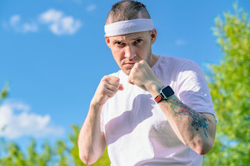 Man practicing martial arts in a green park during daytime, focusing on technique and form while...