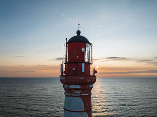 Majestic old lighthouse on the Baltic Sea coast in Estonia at sunset. Picturesque aerial view of...
