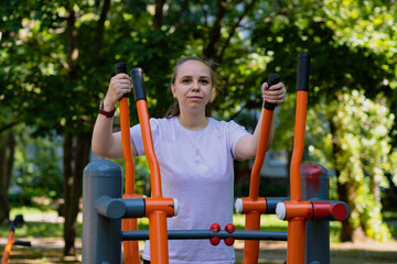 Woman Working Out on Outdoor Exercise Equipment in the Park