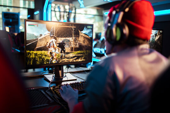 Rear view of a man gaming on a PC in a modern esports arena