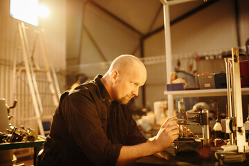 Experienced male mechanic working in a car mechanics shop