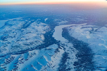 Aerial view of snow mountain and frozen river in colorful morning sunlight in Alaska