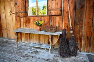 romantic rustic countryside scenery with an old vase with field flowers and red apples in the wicker basket on the wooden bench in the Bavarian village Schwangau, Bavaria, Germany	