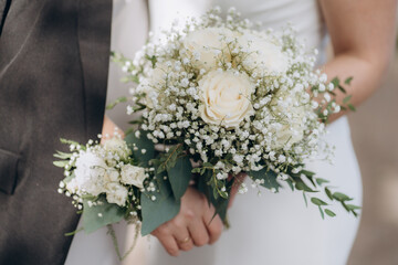 Beautiful bride holds white bouquet. bouquet from white rosses in woman's hands.