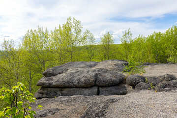 Huge rocks structures geological site in the place of ancient prehistoric ocean trench, nestled within a green forested environment. Rim rocks formation, Western Canada Sedimentary Basin, Alberta
