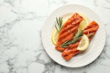 Seafood. Tasty grilled salmon served with rosemary and lemon on white marble table, top view. Space for text