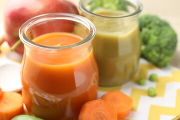 Baby food. Tasty puree in glass jars and ingredients on table, closeup. Space for text