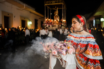 Mujer sahumadora vestida con traje típico tradicional participa en una procesión nocturna durante...