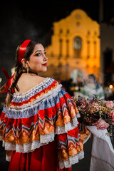 Mujer sahumadora vestida con traje típico tradicional participa en una procesión nocturna durante...