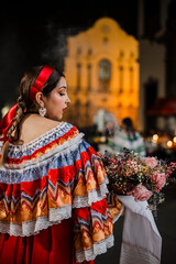 Mujer sahumadora vestida con traje típico tradicional participa en una procesión nocturna durante...