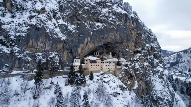 Ostrog Monastery nestled within a snow-covered cliffside landscape Serbia in winter