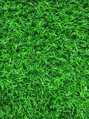 Close-up view of vibrant green artificial grass texture. High-resolution image suitable for backgrounds, sports design, landscaping concepts, or eco-friendly themes