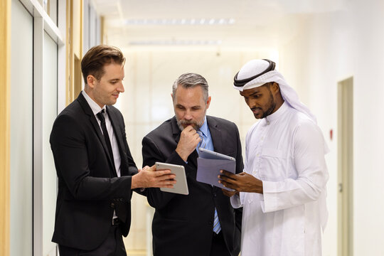 Diverse Team Working Together in Modern Co-Working Space. Casual meeting of smiling diverse business team analyzing financial data. Multiethnic business people working together in the office.