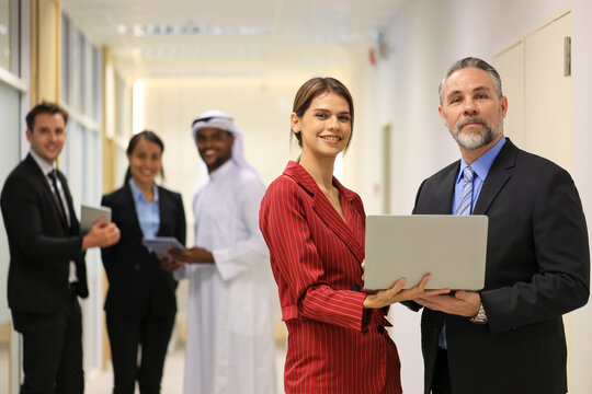 Diverse Team Working Together in Modern Co-Working Space. Casual meeting of smiling diverse business team analyzing financial data. Multiethnic business people working together in the office. - Powered by Adobe