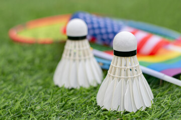 White cream shuttlecock, badminton sport equipment, places on green grass in front of American...