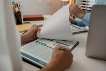 Fototapeta premium the company's auditing staff is checking the documents for accuracy in the office, businessman is explaining information in a document to his partner, graph, entrepreneur, marketing