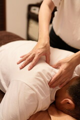 Thumb pressure massage around the shoulder blade