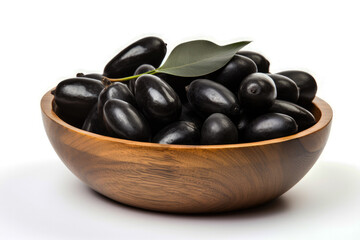 Black olives in a wooden bowl on a white background with depth of field