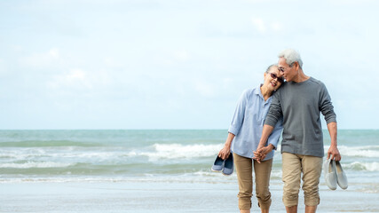 Asian Lifestyle senior couple walking chill on the beach happy in love romantic and relax time after retirement. People tourism elderly family travel leisure and activity after retirement