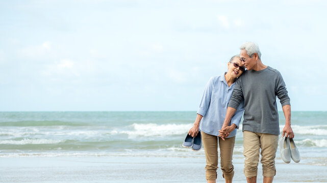 Asian Lifestyle senior couple walking chill on the beach happy in love romantic and relax time after retirement. People tourism elderly family travel leisure and activity after retirement
