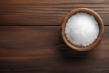 Obraz na płótnie Canvas Top view of a wooden table with a bowl of sea salt