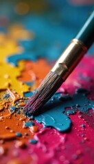 Obraz premium Close-up of a paintbrush resting on a vibrant artist's palette, ready for the next stroke of creative genius Oil paints, textures, and colors are richly displayed , visual arts, vibrant