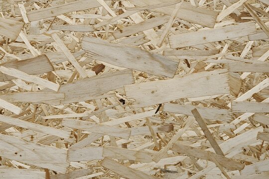 ideal for backgrounds, industrial design projects.a large panel of oriented strand board (OSB), a natural wood grain, Chipboard texture image featuring a light beige surface with visible wood particle