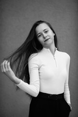 Portrait of a young beautiful dark-haired girl outdoors in winter. Black and white photo.