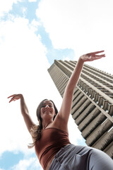Dancer performing in front of a skyscraper under a cloudy sky