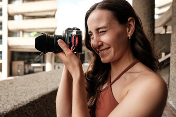 Photographer winking and smiling while taking photos with analog camera