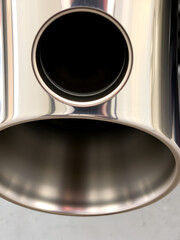 Detailed Close-Up of a Metallic Exhaust Pipe with Circular Holes and Shiny Finish