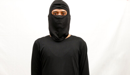 portrait of thief wearing black clothes and mask isolated on white background