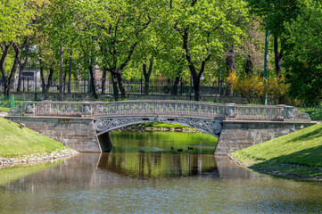 Fototapeta premium Cast iron pedestrian bridge in the city park.