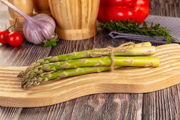 Raw green asparagus over board