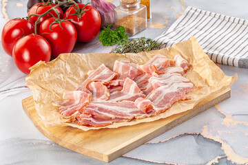 Sliced pork bacon over board