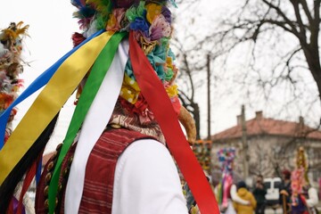 A Kukeri performer in Kalipetrovo, Bulgaria, wears a traditional headdress decorated with colorful...