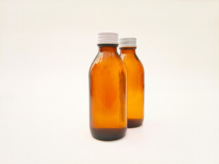 Amber glass bottles with an aluminum cap isolated on a white background, 2 brown glass bottles for pharmaceuticals, syrups, essential oils, and cosmetics