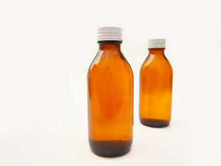 Amber glass bottles with an aluminum cap isolated on a white background, 2 brown glass bottles for pharmaceuticals, syrups, essential oils, and cosmetics
