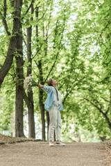 Fototapeta premium Woman Flowers Happiness: Girl holds daisies, enjoys nature, in a park at daytime, feels joyful.