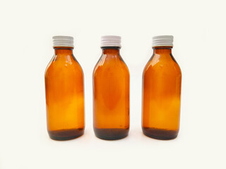 Amber glass bottles with an aluminum cap isolated on a white background, 3 brown glass bottles for pharmaceuticals, syrups, essential oils, and cosmetics