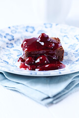 Chocolate brownie with cherry syrup . Selective focus. Copy space.	