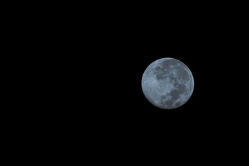 Bright full moon illuminating the dark night sky, revealing lunar craters and its spherical nature...