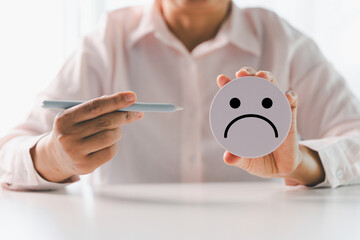 Close up customer hand choose sad face and blurred smiley face icon, Service rating, satisfaction concept. Negative feedback from client often reflects dissatisfaction with quality of service.