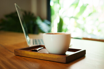 Barista skillfully pouring steamed milk into a cup of espresso, creating latte art in a cozy café during a busy morning.