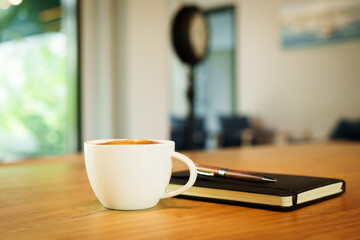 Barista skillfully pouring steamed milk into a cup of espresso, creating latte art in a cozy café during a busy morning.