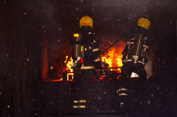 firefighters wearing fire fighter suit for safety and using twirl water extinguisher for fighting the fire flame in emergency situation.. - Safety Firefighter and industrial concept.