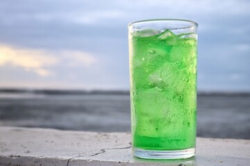 Green soft drink and ice cubes