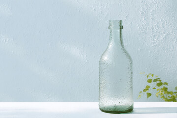glass water bottle glistening in sunlight covered in condensation