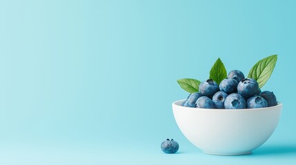 Fresh blueberries in white bowl with green leaves against soft blue background for healthy eating and nutrition concepts
