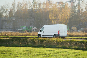 White cargo van on paved countryside road